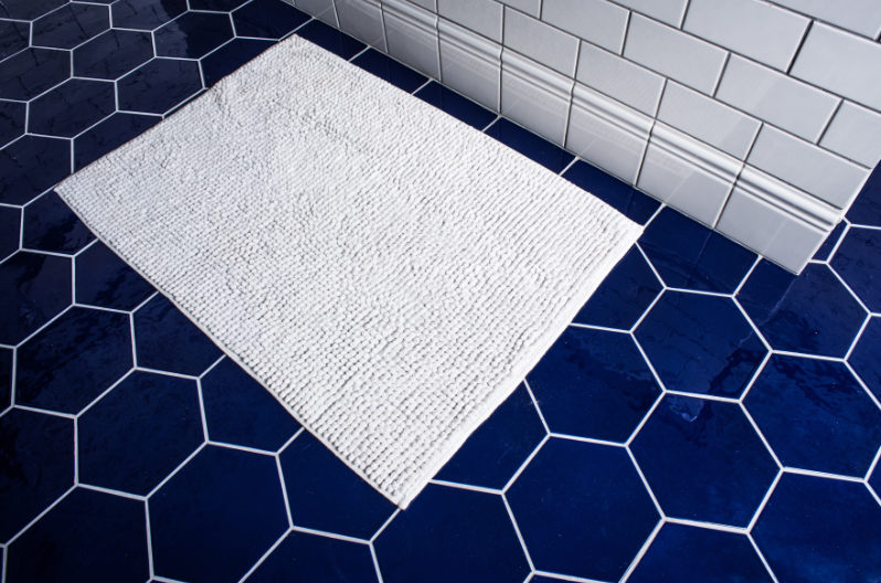 A bathroom with large blue ceramic tiles